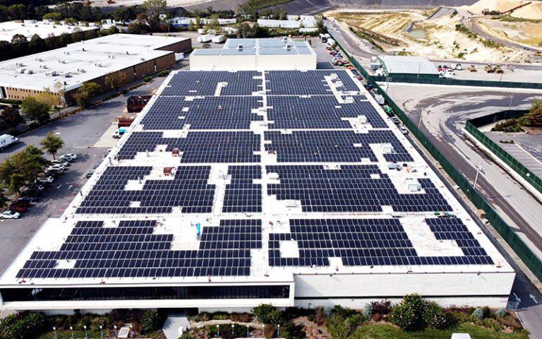 Grande toiture commerciale couverte de panneaux solaires, vue aérienne